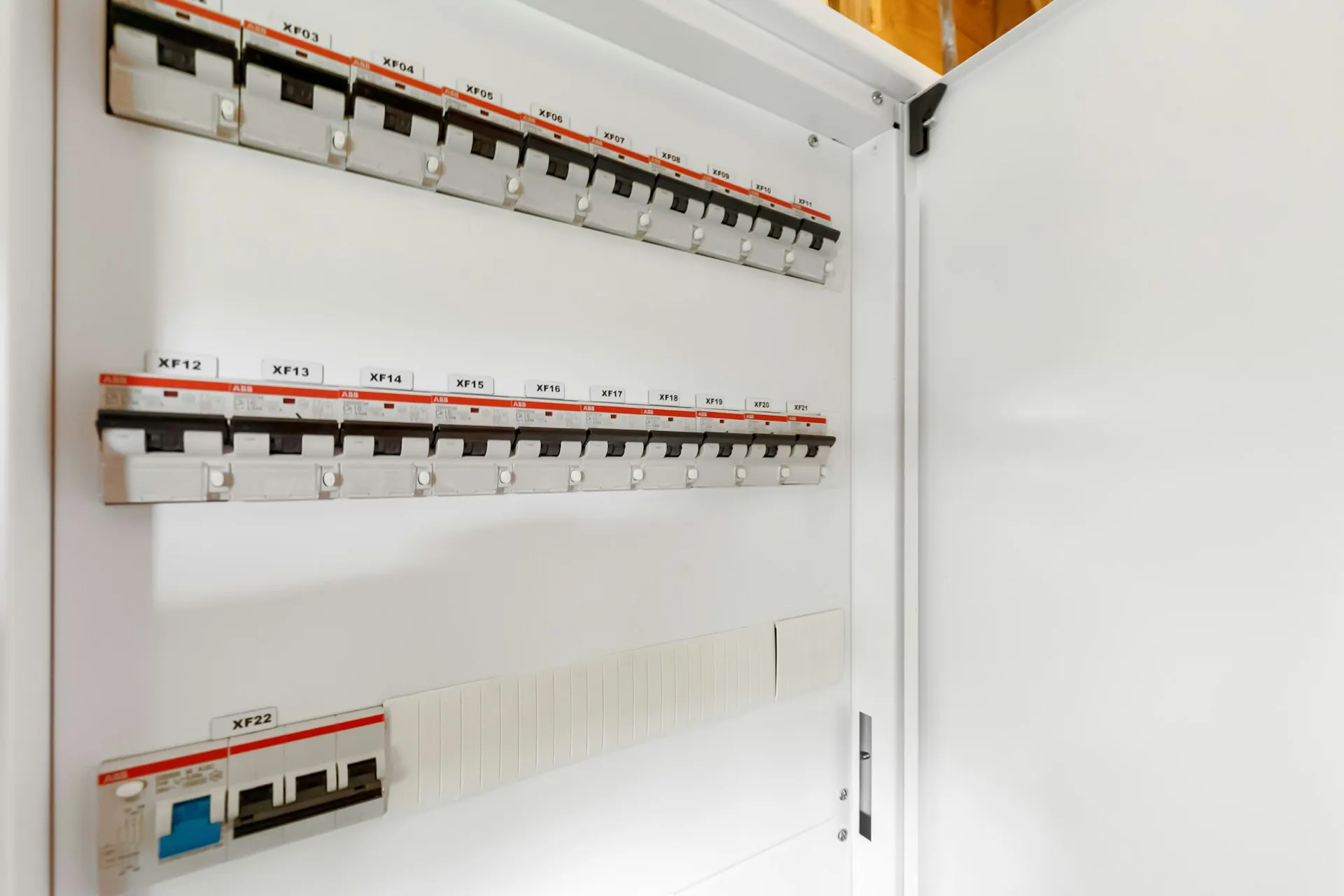 Quadro elétrico branco novo com a porta aberta e disjuntores etiquetados
